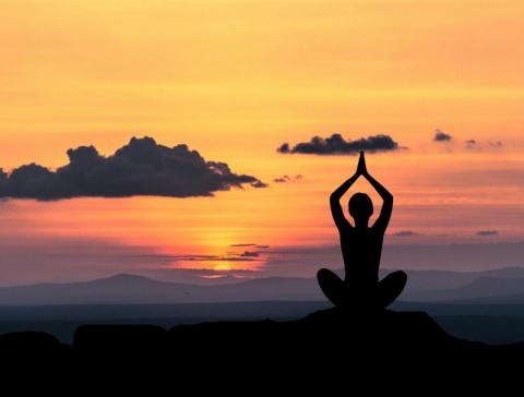 Silhouetted figure in Yoga Pose