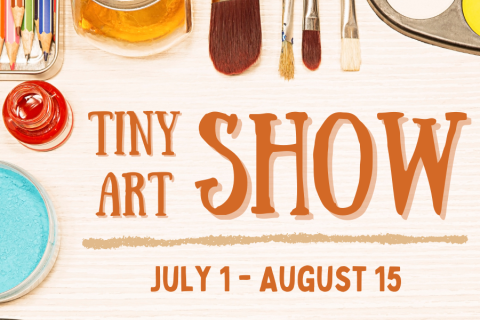 A collection of art supplies scattered on a wooden, beige background advertising the Tiny Art Show.
