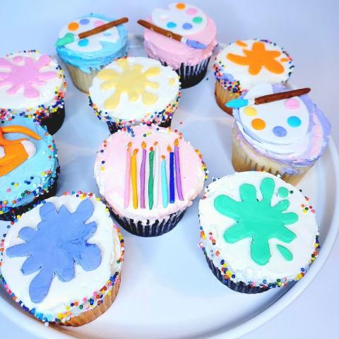 Cupcakes on a tray decorated with art supplies
