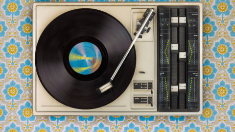 A photograph of a black vinyl record spinning on a turntable. 