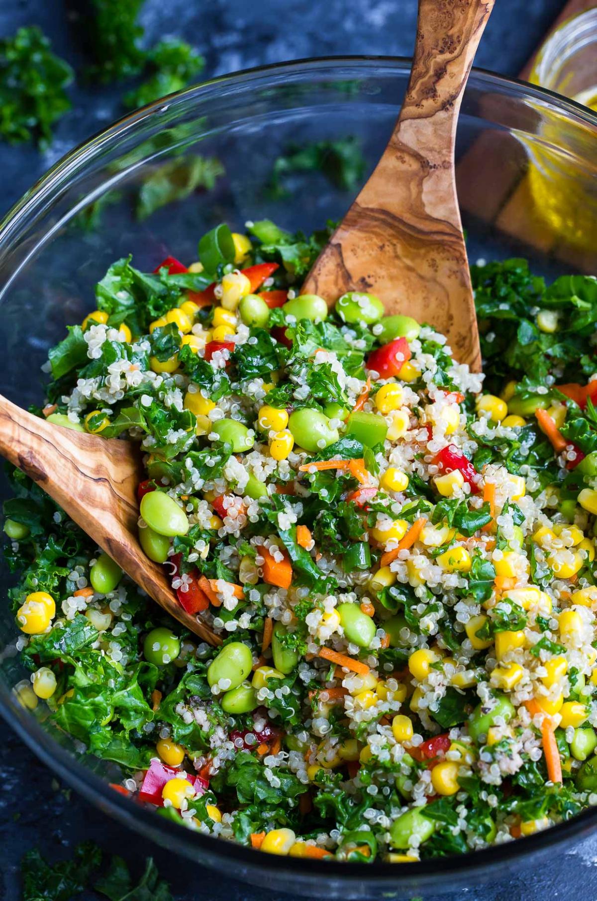 Bowl of salad with quinoa, corn, peas, and greens.