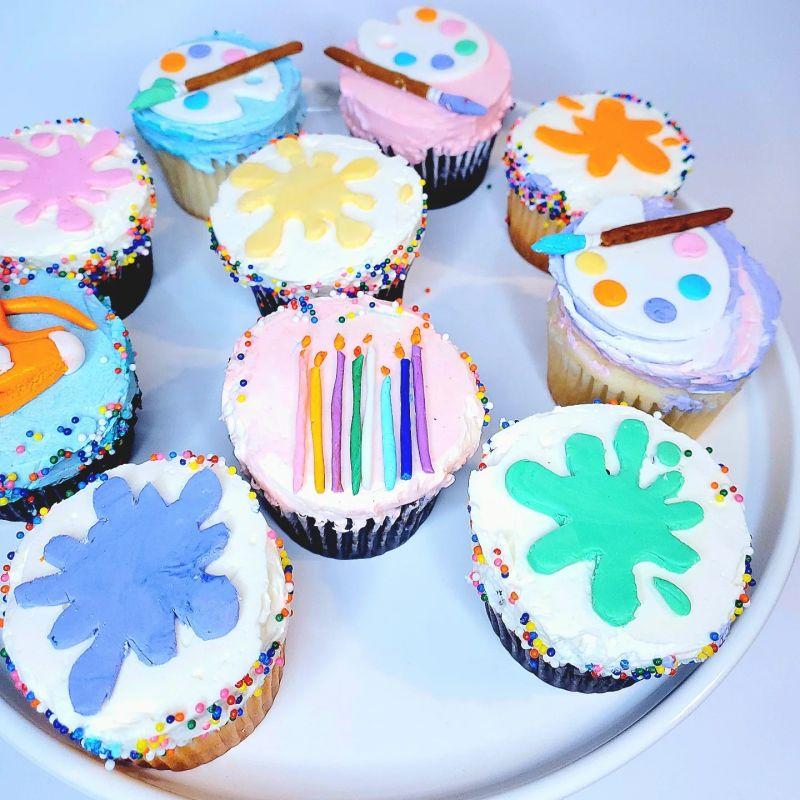 Cupcakes on a tray decorated with art supplies